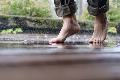 Low section of man standing in water