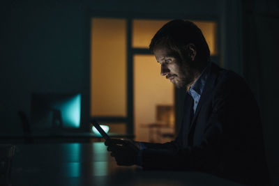 Businessman working late in office using tablet
