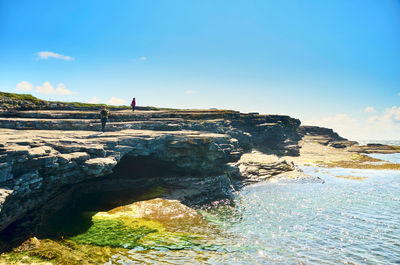 Rock formation on beach against sky