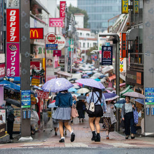 People walking on wet street in city