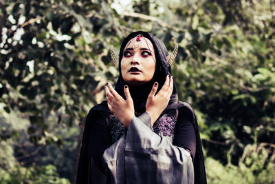 Young woman wearing witch costume while standing outdoors