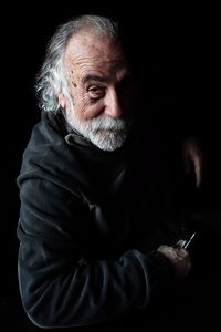 Close-up of young woman against black background