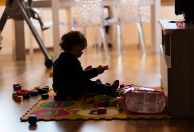 Side view of baby girl playing with toys at home