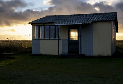 Built structure on field against sky during sunset