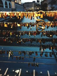 Love padlocks on railing over canal in city at dusk