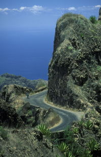 Street by cliff against sky