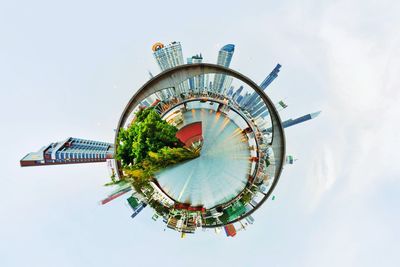 Digital composite image of ferris wheel and building against sky