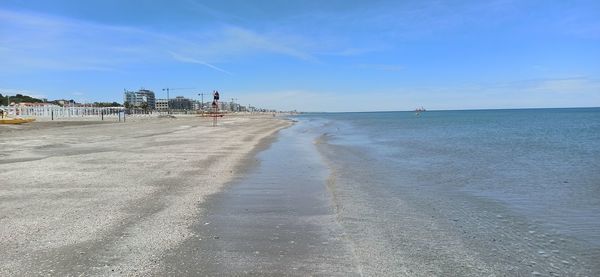 Scenic view of beach against blue sky