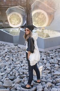 Portrait of young woman standing against wall