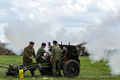 Smoke on field against cloudy sky