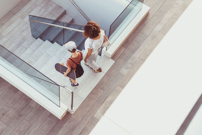 High angle view of mother and son walking on staircase