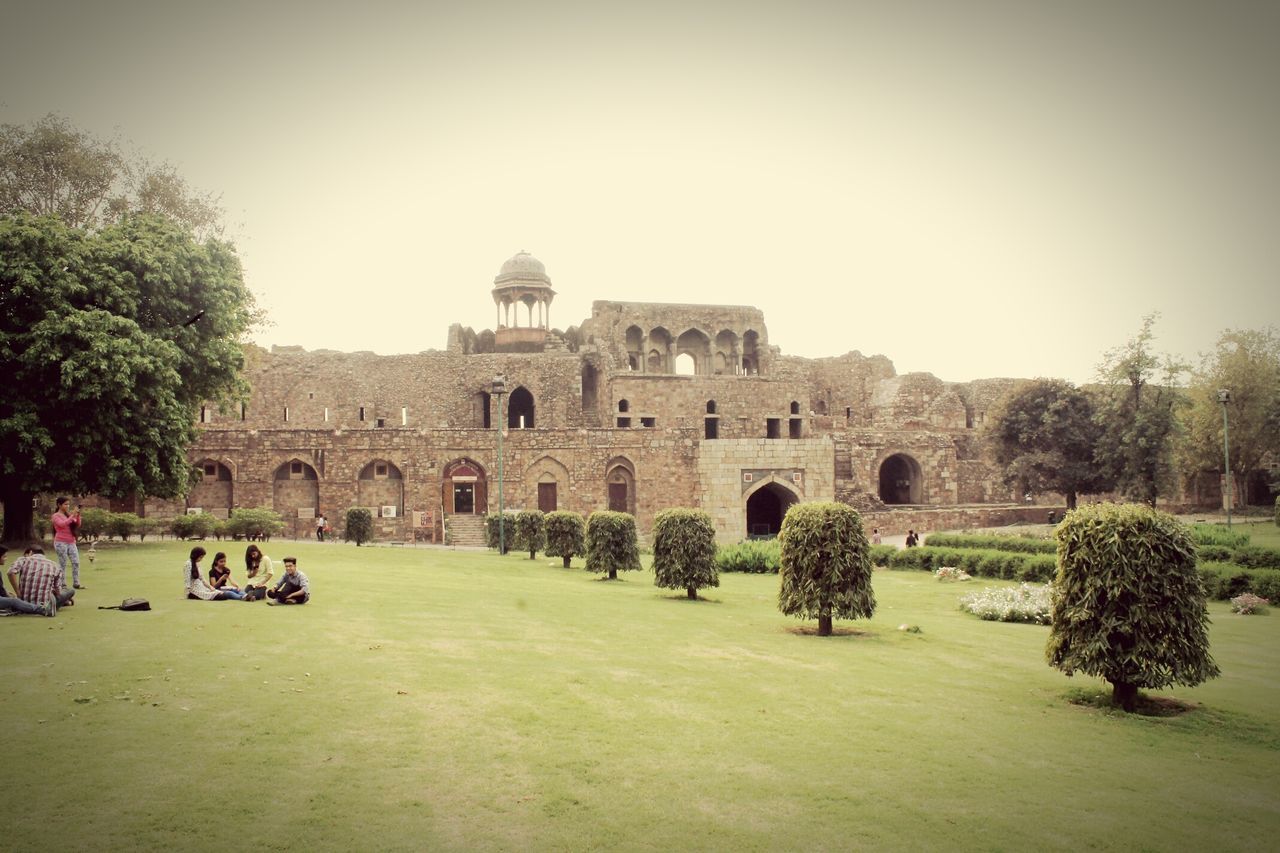 architecture, built structure, building exterior, history, famous place, tourism, tree, arch, old ruin, travel destinations, clear sky, travel, the past, ancient, grass, international landmark, old, tourist, incidental people, large group of people