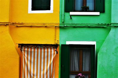 Close-up of windows on yellow and green building