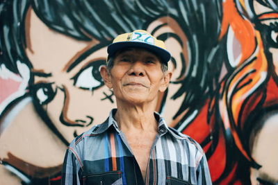 Portrait of smiling woman standing against graffiti wall