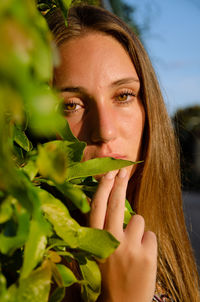 Close-up of young woman holding plant