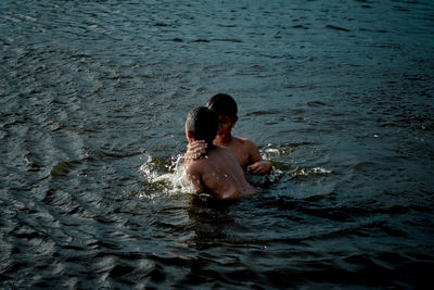 Full length of shirtless man swimming in water
