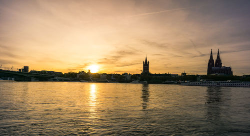 River with buildings in background at sunset