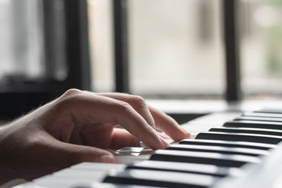 Cropped hand of woman playing piano