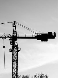 Low angle view of cranes against sky