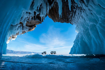 View of cars on frozen lake against sky