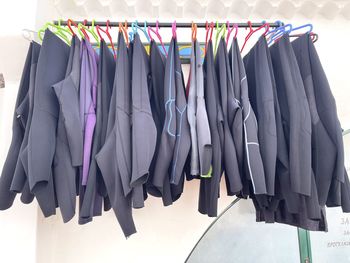 Wetsuits on hangers. drying suits after surfing.