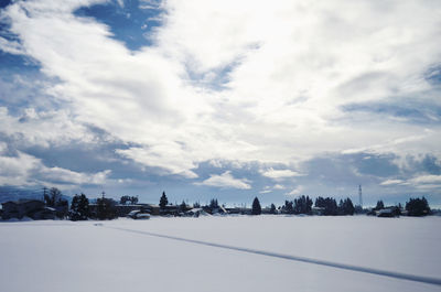 Snow covered city against sky