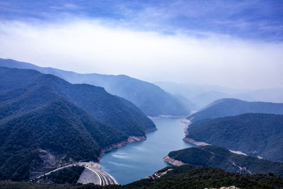 Scenic view of river amidst mountains against sky