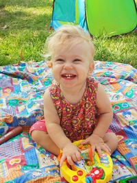 High angle portrait of cheerful baby girl sitting at park