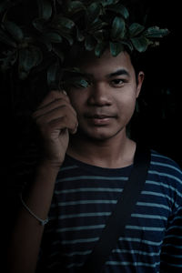 Close-up portrait of man standing by plant