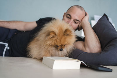 Man lying with dog on sofa