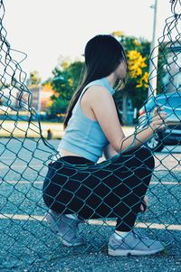 Side view of young woman sitting outdoors