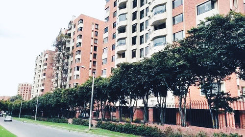 Street by buildings against clear sky