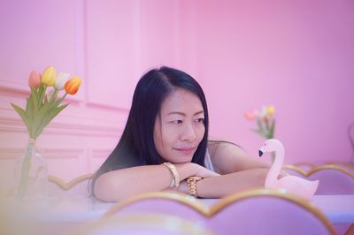 Portrait of beautiful woman against pink flowering plants