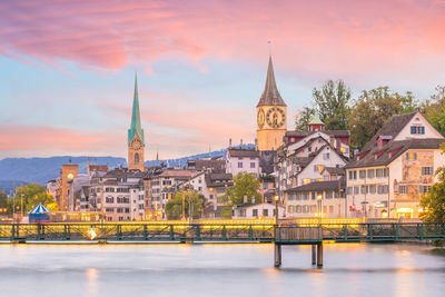 Illuminated buildings against sky at sunset