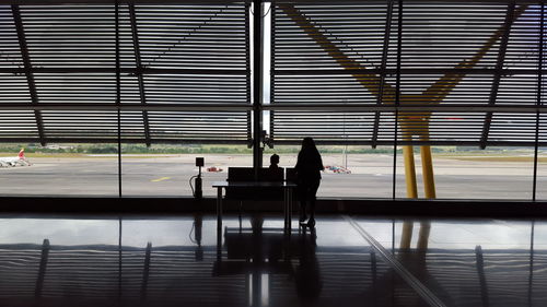 Silhouette people sitting at airport