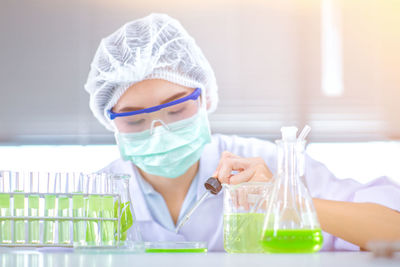 Female scientist performing experiment at table in laboratory