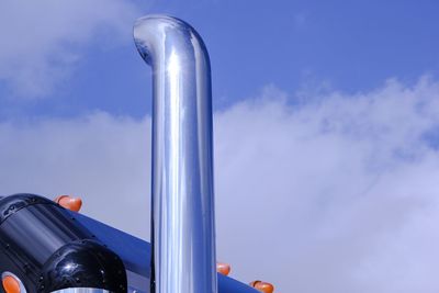 Close-up of chrome motorcycle exhaust pipe against sky
