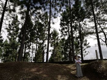 Man amidst trees against sky