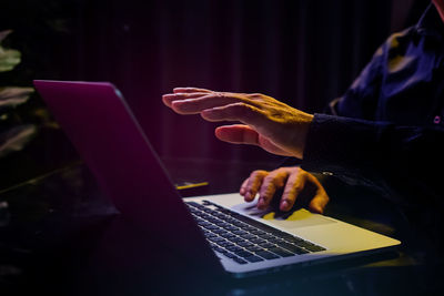 Midsection of woman using laptop on table
