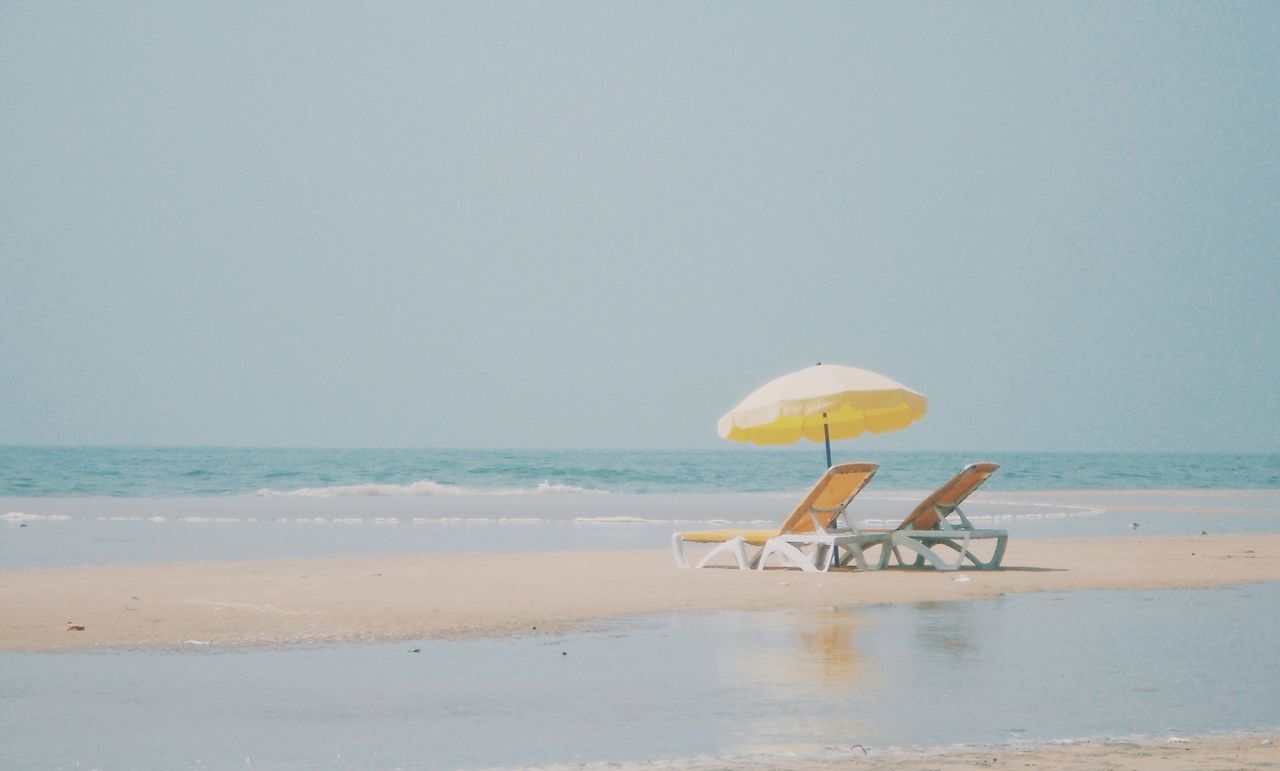 sea, horizon over water, beach, water, sand, shore, tranquil scene, clear sky, tranquility, copy space, scenics, beauty in nature, beach umbrella, nature, vacations, absence, idyllic, parasol, sky, day