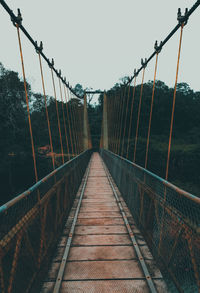 Empty footbridge against clear sky