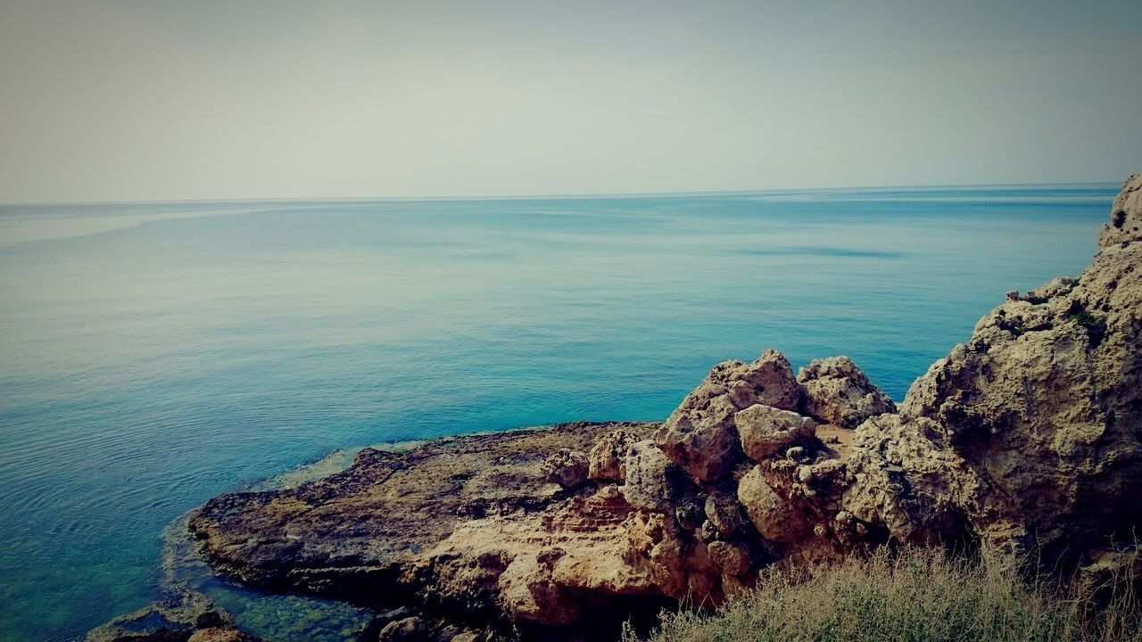 sea, horizon over water, nature, scenics, water, tranquil scene, rock - object, beauty in nature, tranquility, clear sky, no people, sky, blue, outdoors, day, cliff