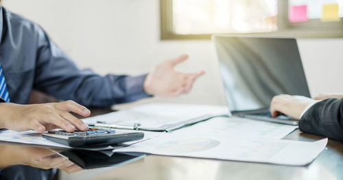 Midsection of businessman working at office