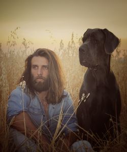 Portrait of man and dog in field