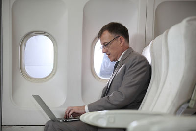 Midsection of man sitting in airplane