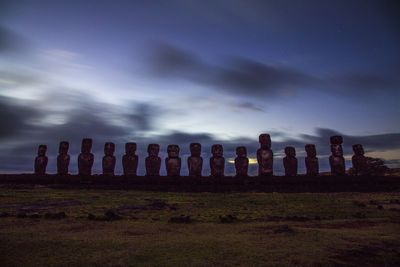 Statues on field against sky 