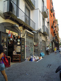 People walking on street amidst buildings in city