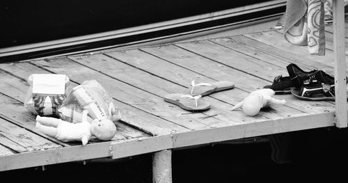 High angle view of dolls with slippers on pier
