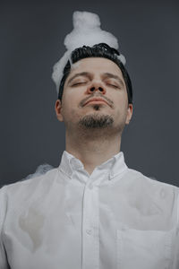 Portrait of young man against black background