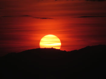 Scenic view of silhouette mountain against orange sky